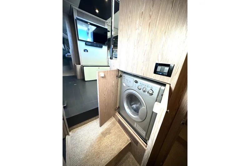 Bellisima Yacht Photos Pics Laundry area inside 2019 Azimut Atlantis 51 yacht, featuring a built-in washing machine.