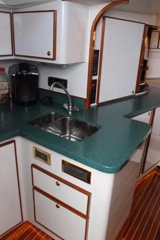 M.a.c. Daddy Yacht Photos Pics 2005 Custom DeSanti Carolina Express boat kitchen with green countertop and stainless steel sink.