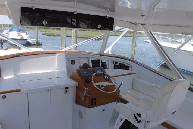 M.a.c. Daddy Yacht Photos Pics Helm of 2005 Custom DeSanti Carolina Express boat with white seating and wooden accents.