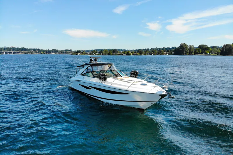  Yacht Photos Pics 2018 Cobalt 46 Yacht cruising on a serene lake under a clear blue sky.