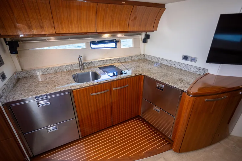  Yacht Photos Pics Luxurious kitchen interior of 2018 Cobalt 46 Yacht with granite countertops and wood cabinetry.