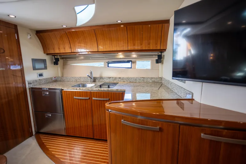  Yacht Photos Pics Luxurious 2018 Cobalt 46 Yacht interior kitchen with sleek wood cabinetry and granite countertops.