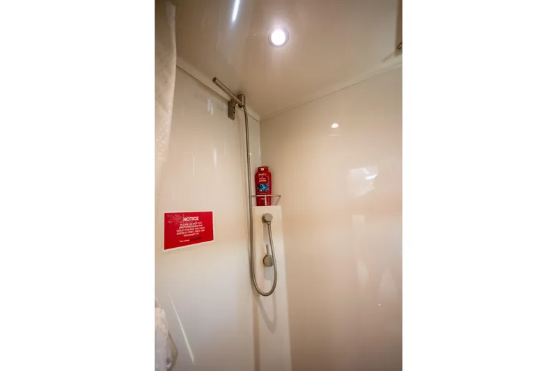  Yacht Photos Pics Shower area in 2018 Cobalt 46 Yacht with handheld showerhead and notice sign.