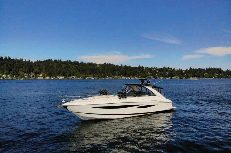  Yacht Photos Pics 2018 Cobalt 46 Yacht cruising on a serene lake with forested shoreline.