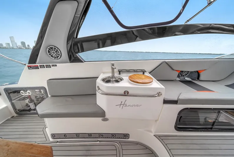  Yacht Photos Pics 2024 Hanover 305 boat interior with seating, sink, and city skyline view.