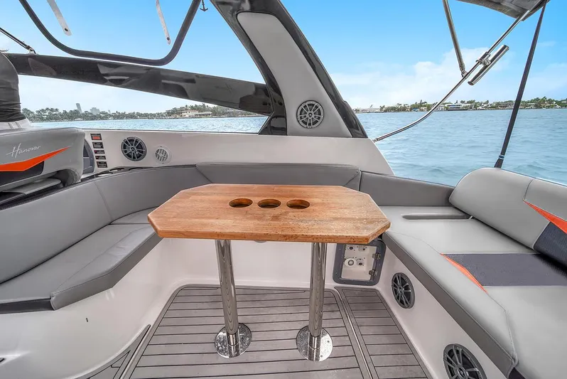  Yacht Photos Pics Luxurious 2024 Hanover 305 boat interior with wooden table and comfortable seating.