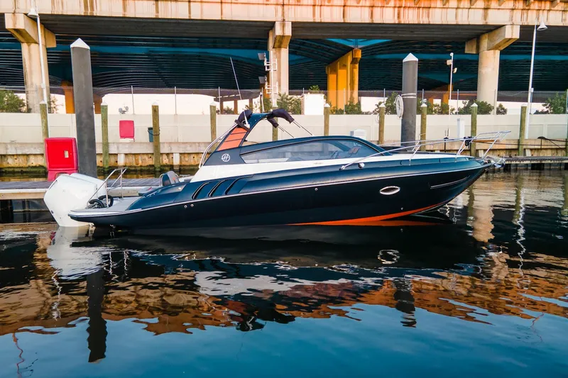  Yacht Photos Pics 2024 Hanover 305 boat docked under a bridge, reflecting on calm water.