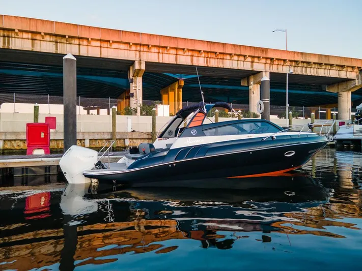  Yacht Photos Pics 2024 Hanover 305 boat docked under a bridge, reflecting on calm water.