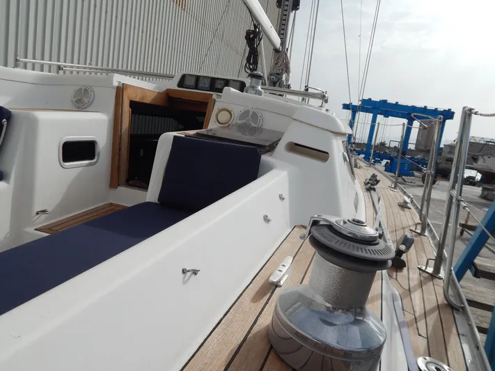  Yacht Photos Pics 1999 Oyster 42 Aft Cockpit Deck Saloon yacht with blue cushions and wooden deck.
