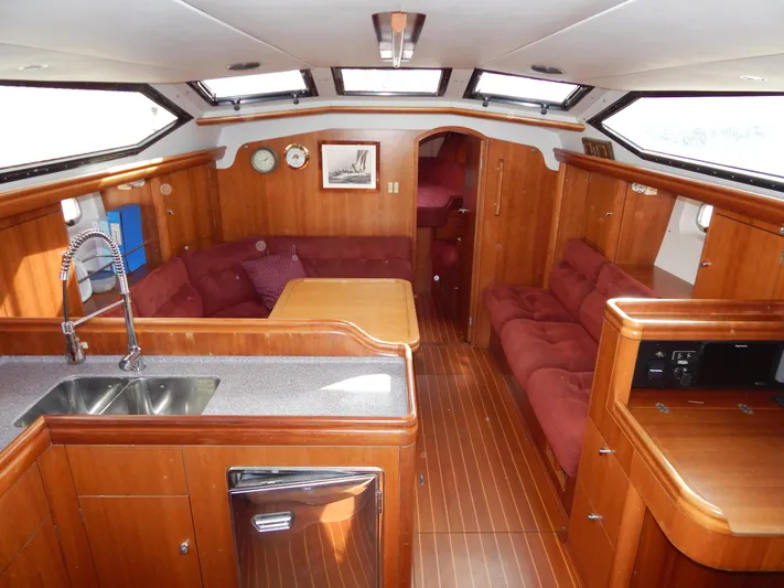  Yacht Photos Pics Luxurious interior of 1999 Oyster 42 yacht with wood finish and plush seating.