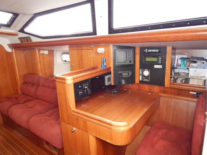  Yacht Photos Pics Interior of 1999 Oyster 42 yacht with navigation station and plush seating.