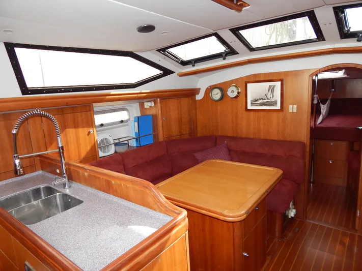 Yacht Photos Pics Interior of 1999 Oyster 42 yacht with wood finish, saloon, and kitchen area.