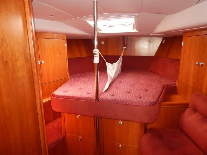  Yacht Photos Pics Luxurious cabin interior of 1999 Oyster 42 yacht with red upholstery and wood finish.