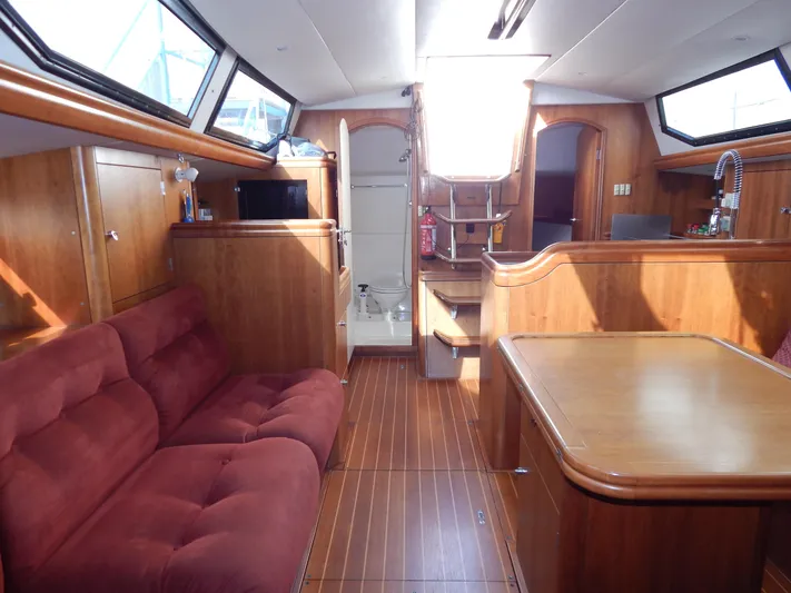  Yacht Photos Pics Interior of 1999 Oyster 42 yacht with wood finish and red sofa.