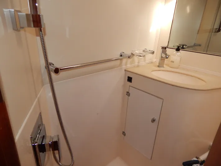  Yacht Photos Pics Compact bathroom in 1999 Oyster 42 yacht with shower, sink, and storage cabinet.