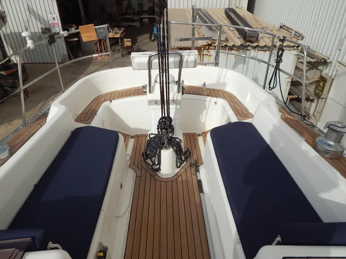  Yacht Photos Pics Aft cockpit of 1999 Oyster 42 yacht with teak decking and blue cushions.