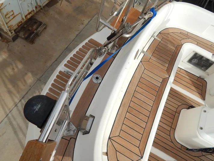  Yacht Photos Pics Teak deck of 1999 Oyster 42 Aft Cockpit Deck Saloon yacht, featuring stainless steel fittings.