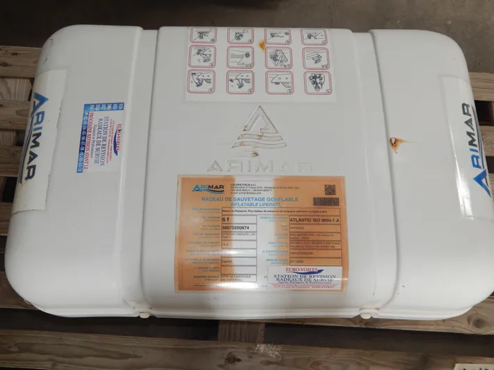  Yacht Photos Pics Arimar inflatable liferaft on wooden pallet, featuring safety instructions and labels.