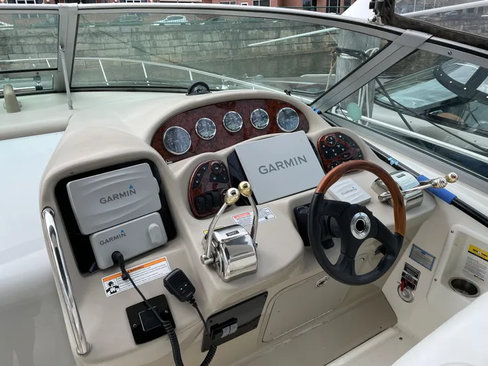 Viva La Vida Yacht Photos Pics 2006 Sea Ray 340 Sundancer helm with Garmin navigation system and wood-accented steering wheel.