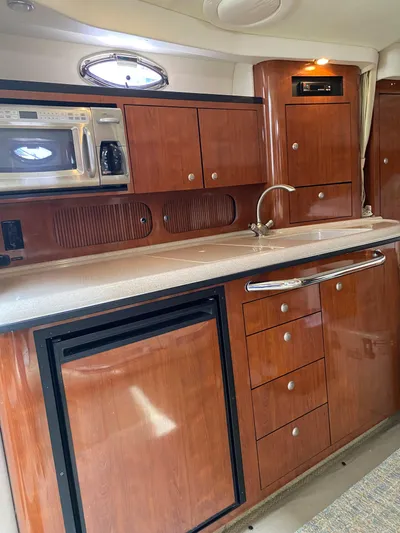 Viva La Vida Yacht Photos Pics 2006 Sea Ray 340 Sundancer kitchen with wood cabinets, microwave, and sink.