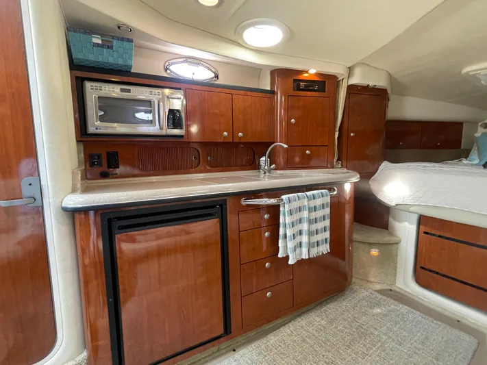 Viva La Vida Yacht Photos Pics Interior of 2006 Sea Ray 340 Sundancer with kitchenette and cozy sleeping area.