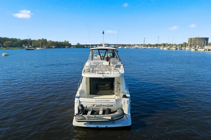 Endymion Yacht Photos Pics 2006 Carver 56 Voyager yacht on calm water, marina in background.