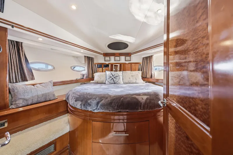 Endymion Yacht Photos Pics Luxurious 2006 Carver 56 Voyager yacht bedroom with plush bedding and elegant wood finishes.