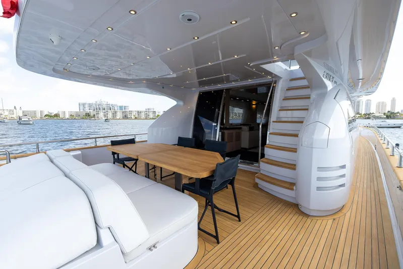 Sea Metri V Yacht Photos Pics Luxurious 2017 Amer 94 yacht deck with seating, table, and stairs, overlooking waterfront cityscape.