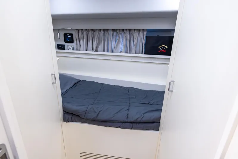Sea Metri V Yacht Photos Pics Compact cabin bed in Amer 94 yacht, 2017 model, with gray bedding and storage.