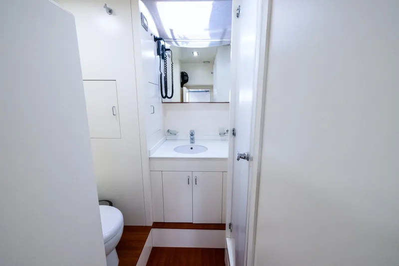 Sea Metri V Yacht Photos Pics Compact bathroom in a 2017 Amer 94 model yacht, featuring modern fixtures and white cabinetry.