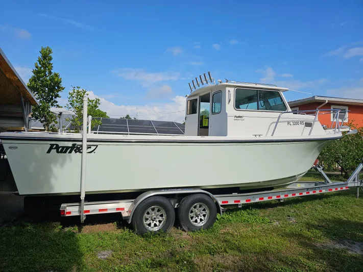  Yacht Photos Pics 2017 Parker 2820 XLD Sport Cabin boat on trailer, parked outdoors under blue sky.