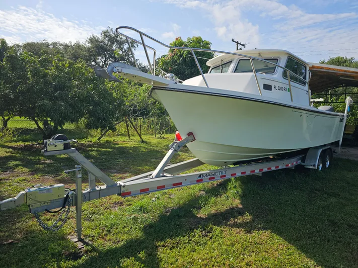  Yacht Photos Pics 2017 Parker 2820 XLD Sport Cabin boat on trailer, parked on grass.
