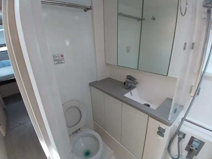 Sail La Vie Yacht Photos Pics Compact bathroom in 2019 Leopard 45 yacht with toilet, sink, and mirror.