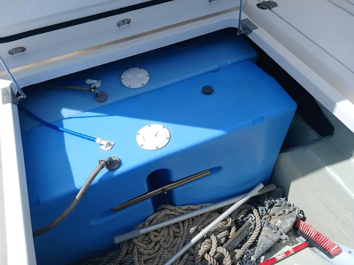 Sail La Vie Yacht Photos Pics Blue water tank in Leopard 45 yacht storage compartment, surrounded by ropes and equipment.
