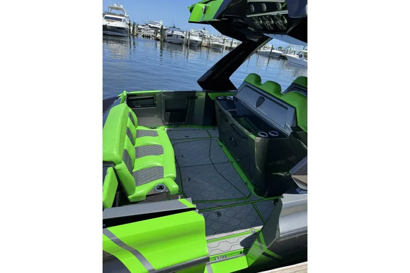  Yacht Photos Pics 2023 Adrenaline 47 boat interior with vibrant green seating, docked at a marina.