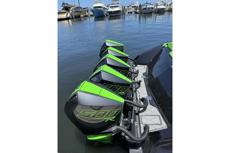  Yacht Photos Pics Four green and black 500R outboard motors on a 2023 Adrenaline 47 boat at a marina.
