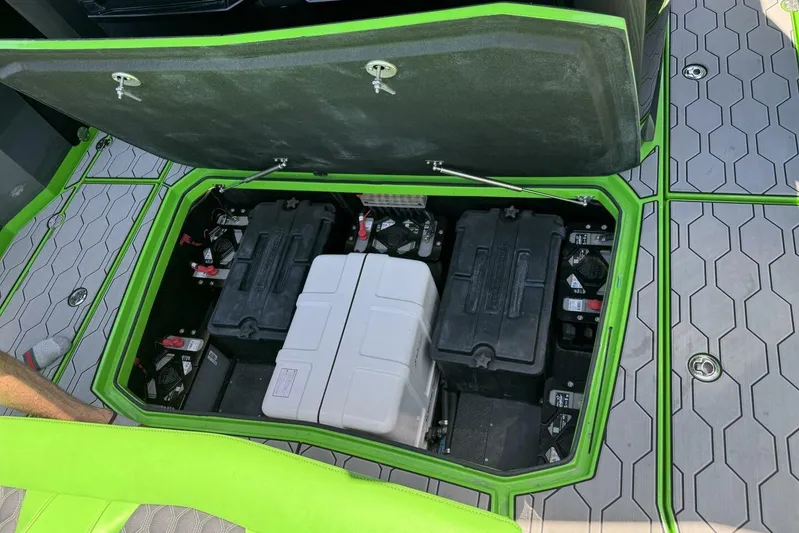  Yacht Photos Pics Open battery compartment of 2023 Adrenaline 47 boat with green trim and hexagonal flooring.