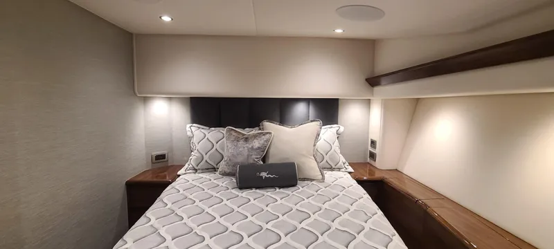 Nomad Yacht Photos Pics Luxurious bedroom interior of 2024 Viking 54 Convertible yacht with elegant bedding.