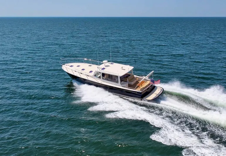 Highlander Yacht Photos Pics 2017 MJM 50z yacht cruising on open sea with American flag.