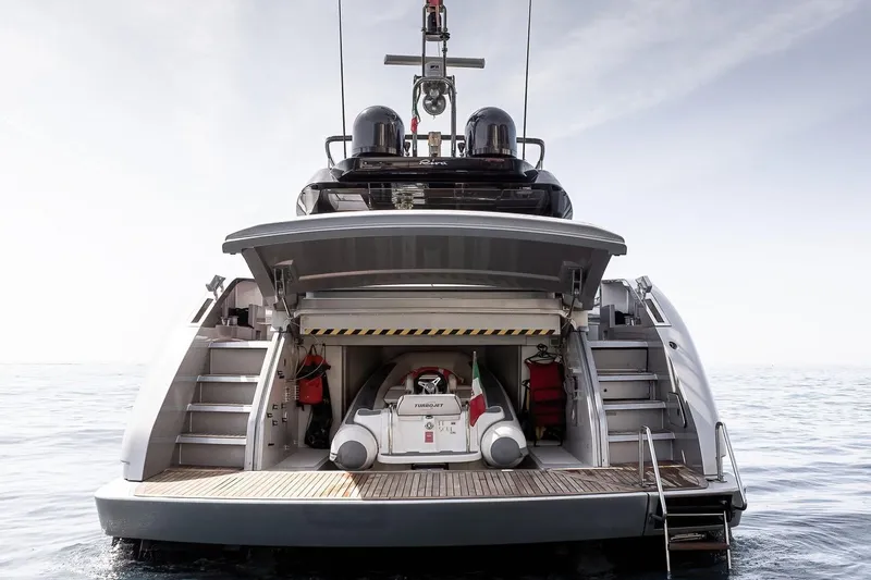  Yacht Photos Pics Sleek 2016 Riva 76' Perseo yacht with open garage and tender on calm sea.