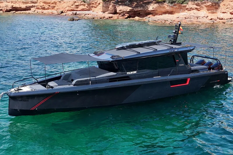 Ex Felgenhauer Yacht Photos Pics 2023 BRABUS Shadow 1200 Cross Cabin yacht on clear blue water near rocky shore.