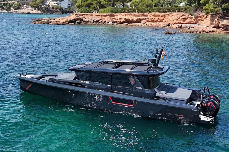 Ex Felgenhauer Yacht Photos Pics 2023 BRABUS Shadow 1200 Cross Cabin yacht on clear blue water near rocky shore.