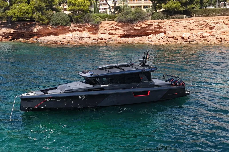 Ex Felgenhauer Yacht Photos Pics 2023 BRABUS Shadow 1200 Cross Cabin yacht on clear blue water near rocky shoreline.