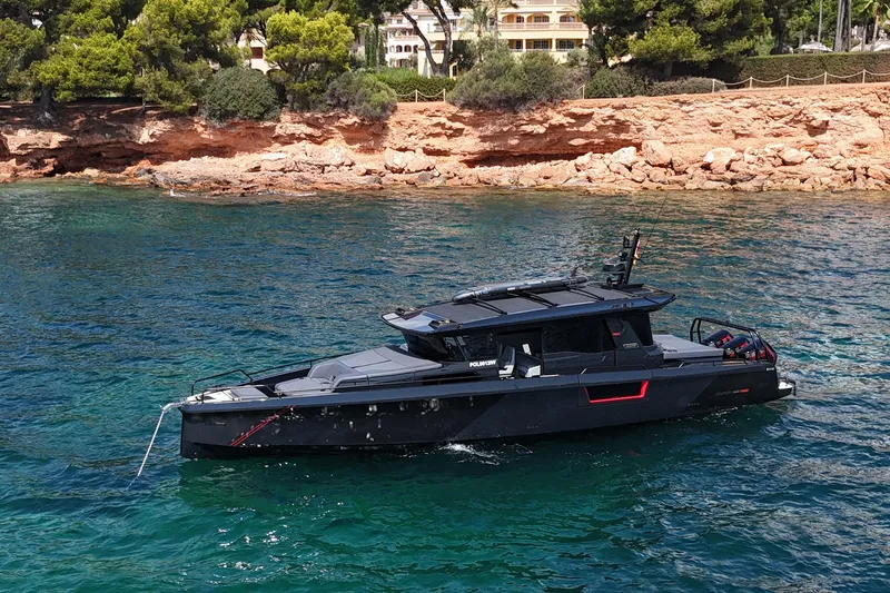 Ex Felgenhauer Yacht Photos Pics 2023 BRABUS Shadow 1200 Cross Cabin yacht on clear blue water near rocky shoreline.