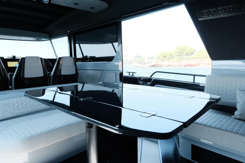 Ex Felgenhauer Yacht Photos Pics Luxurious interior of 2023 BRABUS Shadow 1200 Cross Cabin yacht with sleek seating and table.