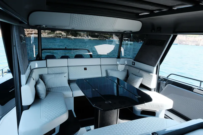 Ex Felgenhauer Yacht Photos Pics Luxurious interior of 2023 BRABUS Shadow 1200 Cross Cabin yacht with elegant seating and table.