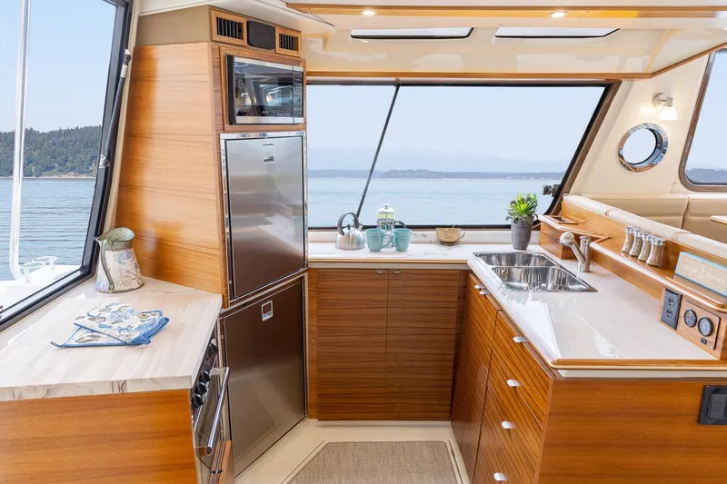  Yacht Photos Pics Luxurious 2025 Ranger Tugs R-43 S yacht kitchen with modern appliances and scenic ocean view.
