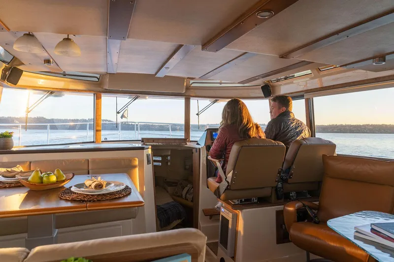  Yacht Photos Pics Interior of 2025 Ranger Tugs R-43 S, featuring a cozy cabin with two people enjoying the view.
