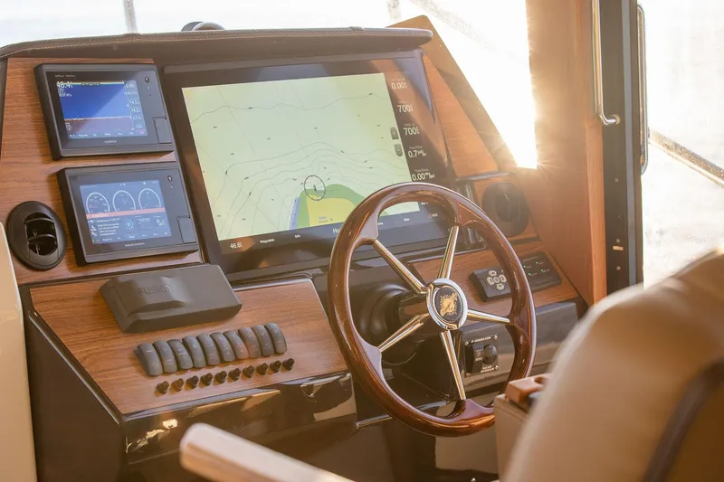  Yacht Photos Pics 2025 Ranger Tugs R-43 S helm with navigation screens and wooden steering wheel.