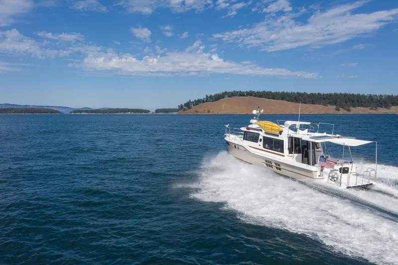  Yacht Photos Pics 2025 Ranger Tugs R-43 S cruising on open water under a clear sky.